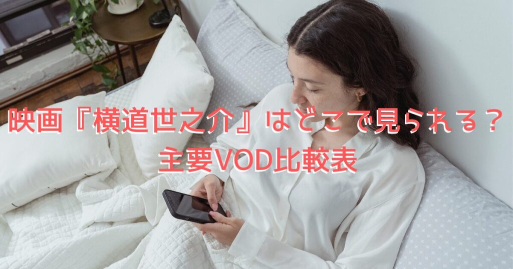 配信サイトの利用をイメージした、部屋でくつろぎながらスマホで映画を見る女性の画像