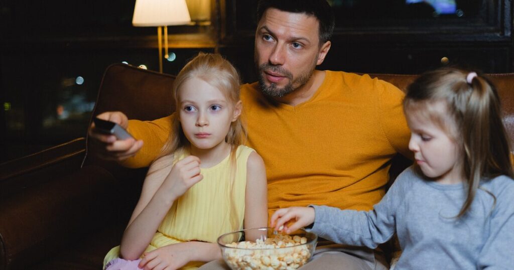 部屋で親子が映画を見ている様子、リメンバー・ミーは親子でも楽しめる作品であることをイメージした画像