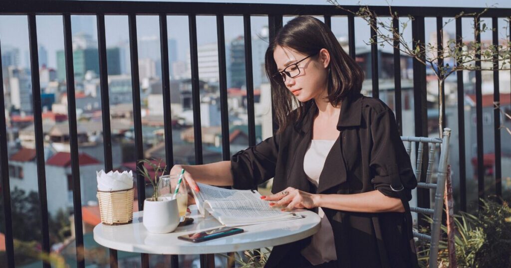 女性がカフェのテラス席で仕事をしている画像