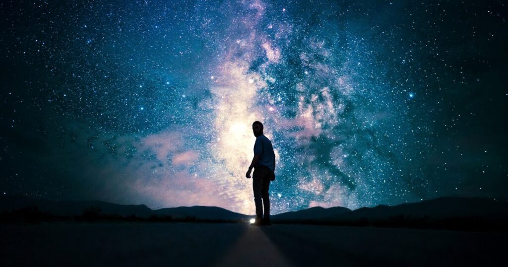 映画『プロジェクト・ヘイル・メアリー』をイメージした、満点の星空とそれを見上げている人の画像