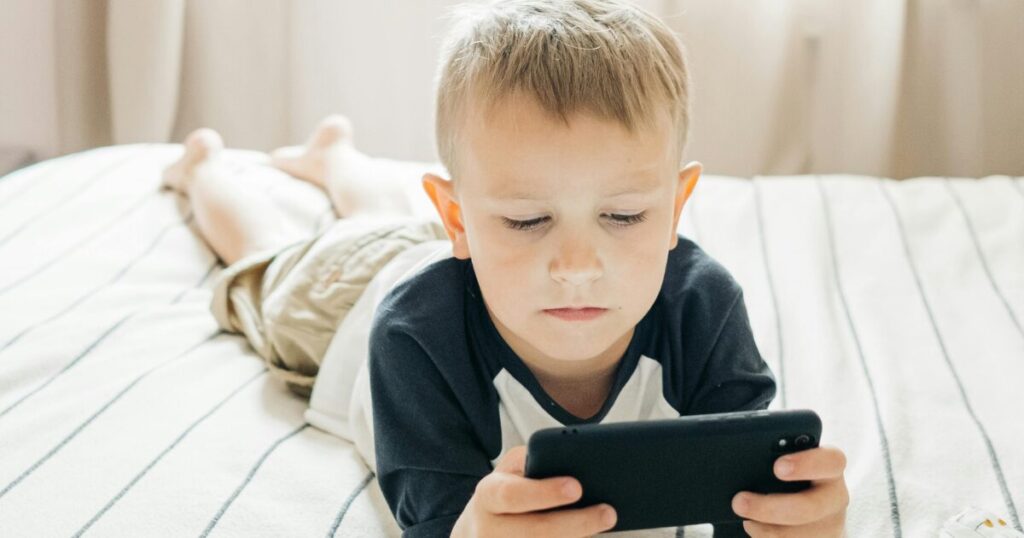 おもちゃのデジタル化をイメージ、子供がスマートフォンで遊んでいる画像